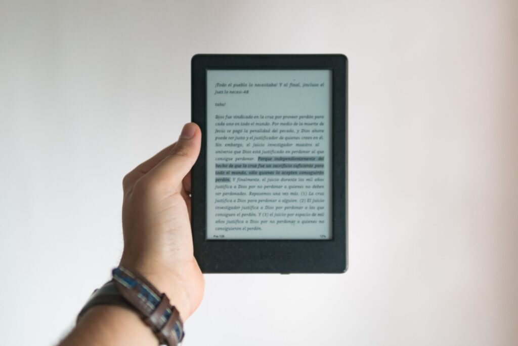 Person holding Kindle in hand with opened e-book